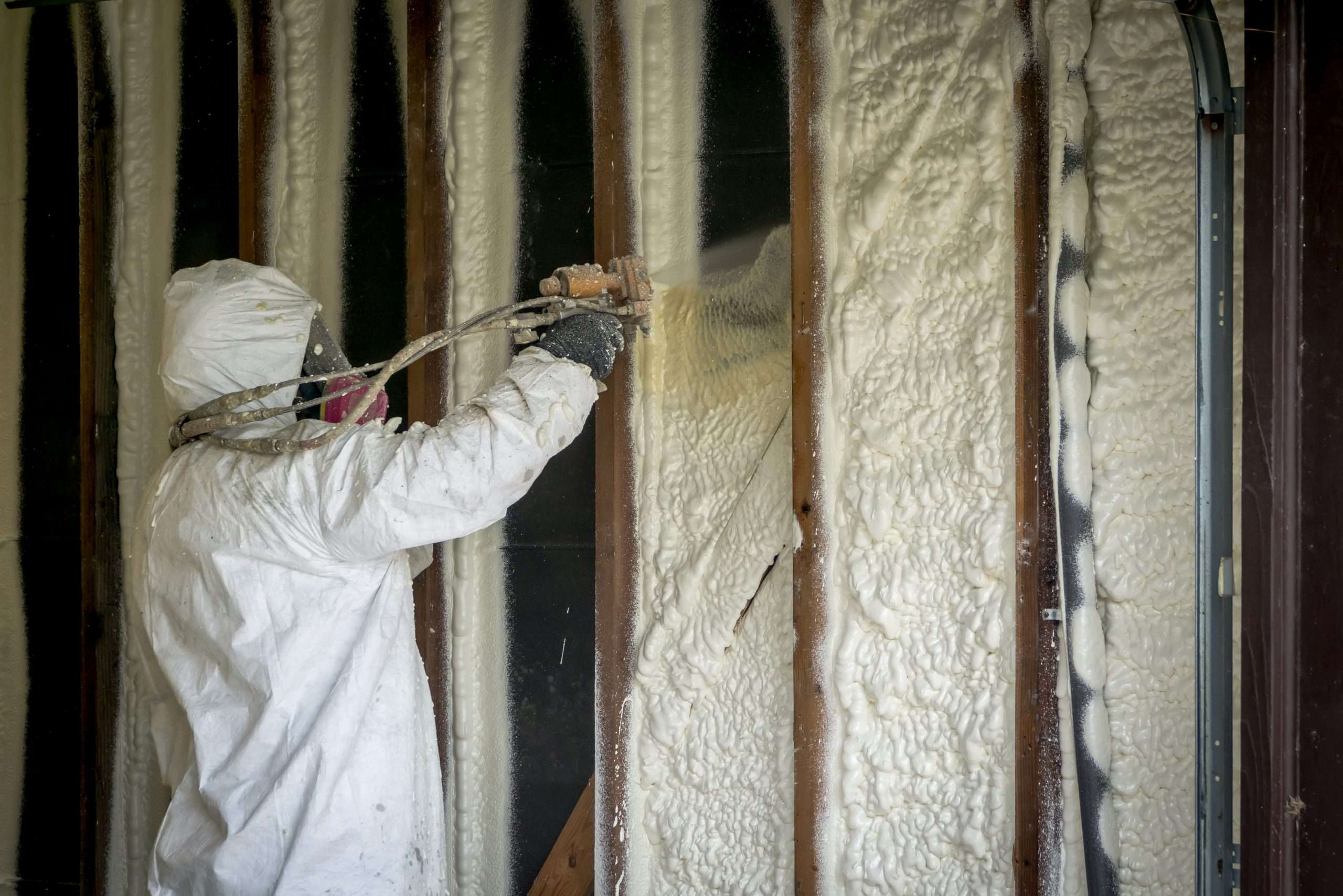 Worker spraying closed cell spray foam insulation on a home that Spray Foam Insulation | Complete Basement Systems | Long Island, NY